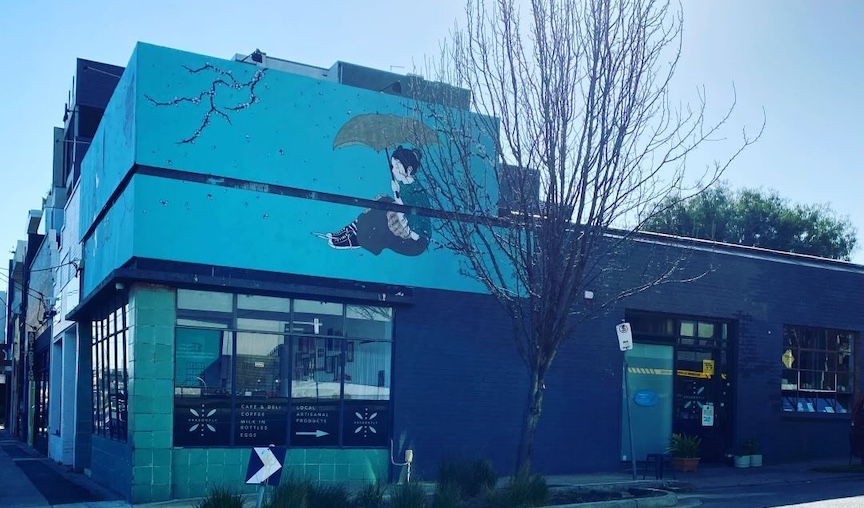 Image of the facade of Dragonfly Cafe & Deli. A blue building on a street corner in Melbourne, Australia.